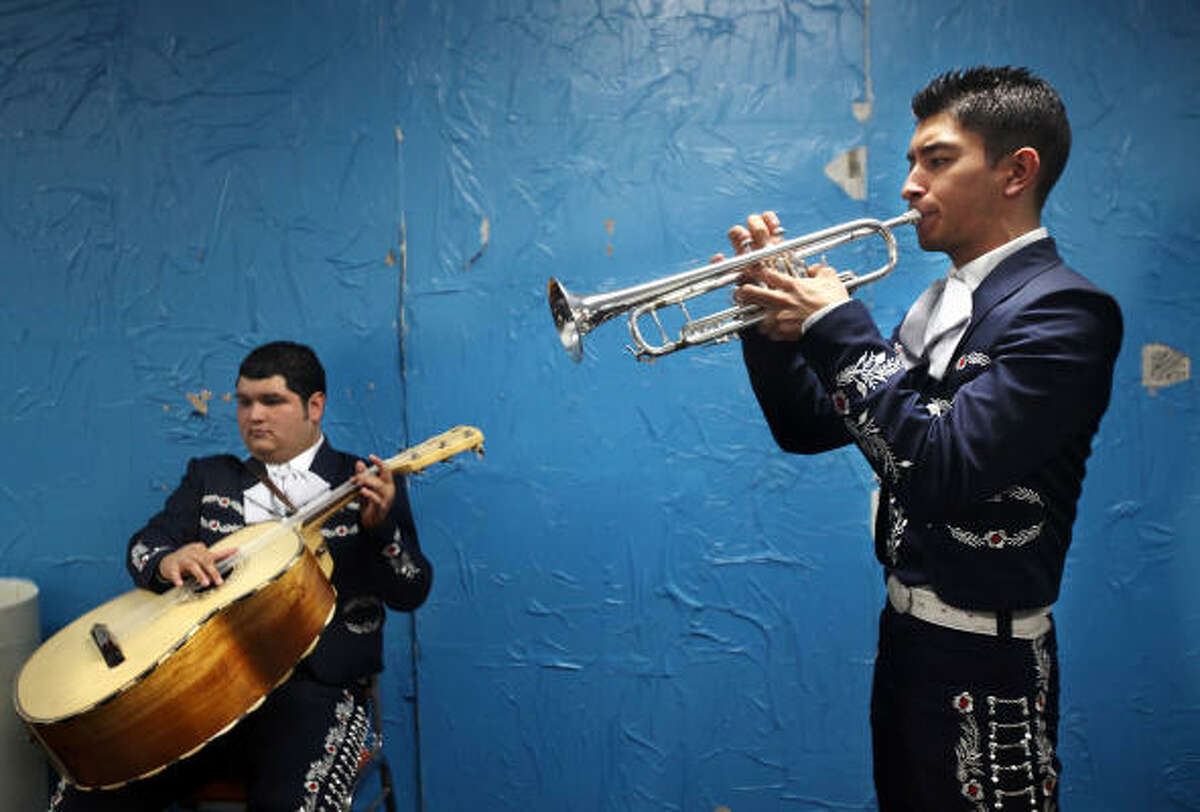 Fabian Rivera, left, and David Moreno, both with Mariachi Aztlan from the University of Texas-Pan American, warm up before performing To Cross the Face of the Moon at Talento Bilingue de Houston.