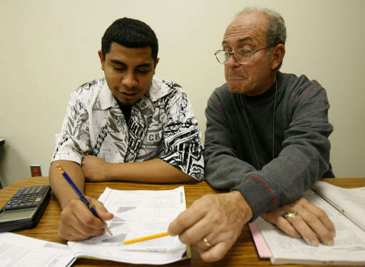 Daniel Villarreal, left, a senior at Crossroads alternative school in the Alief Independent School District, gets help from Raul Blanco before a test﻿. The 19-year-old says he appreciates the “one-on-one time”﻿ from the program.