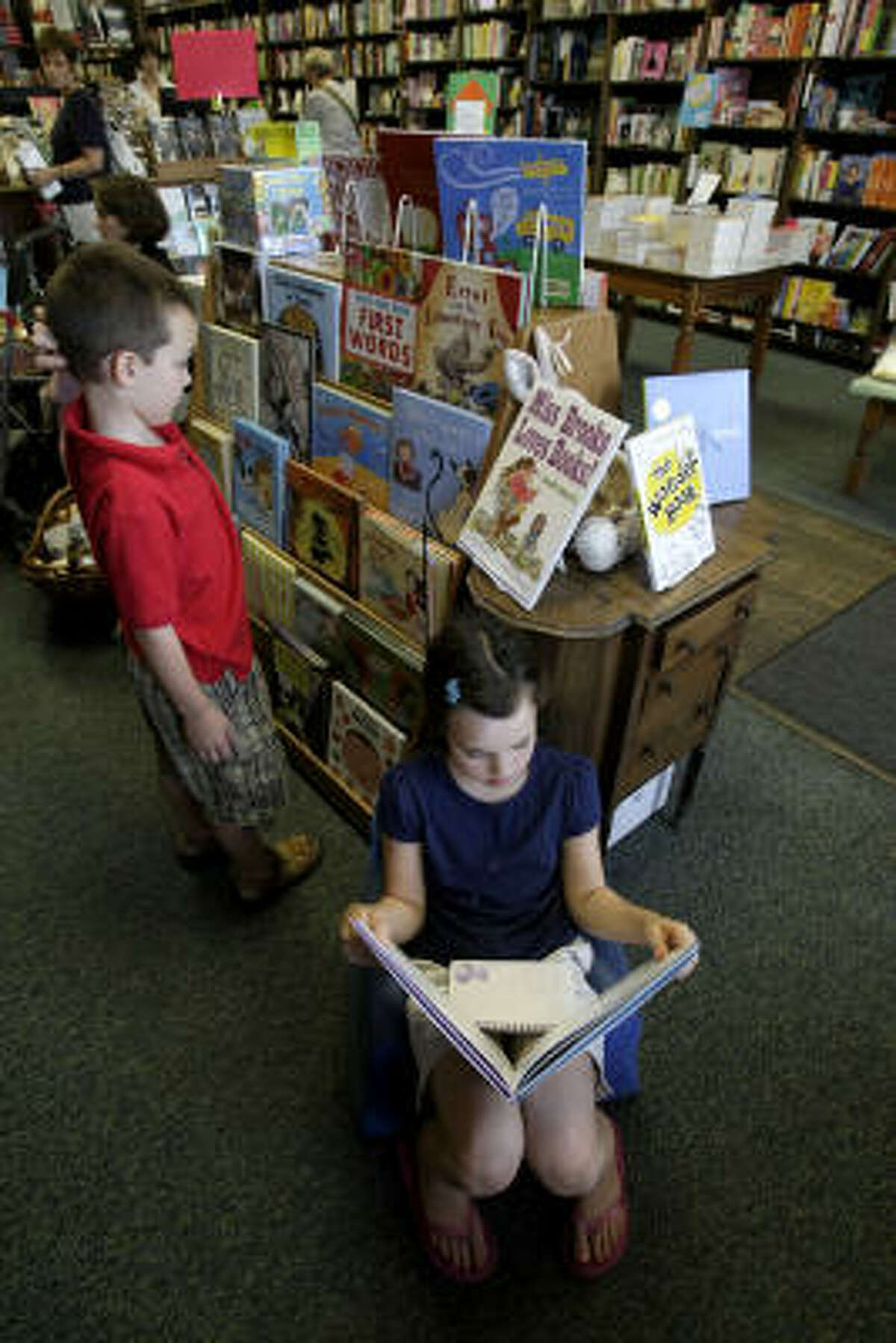 Kiley Hatch, 9, and her brother John Austin Hatch, 7, spend some time at the west Memorial area's Blue Willow Bookshop, which is having a strong year.