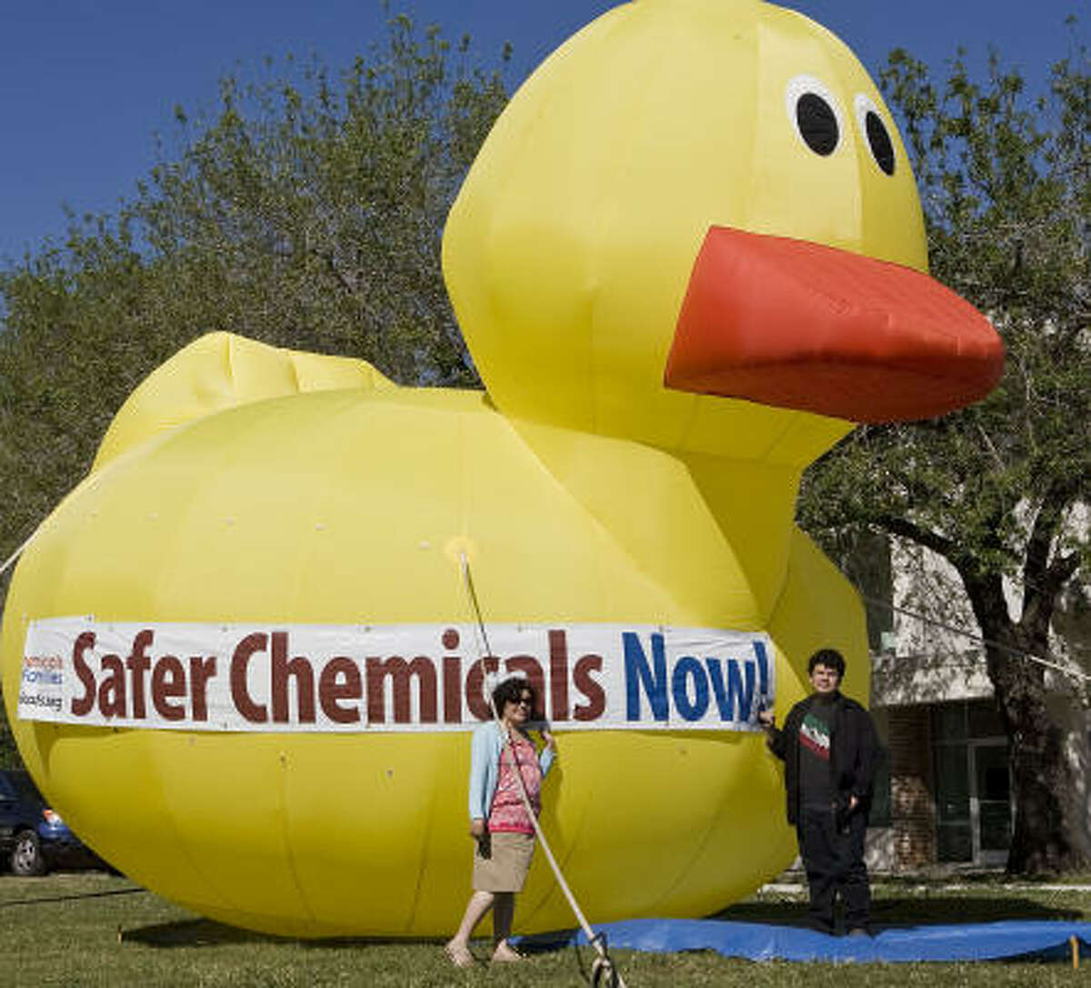 Rosalia Guerrero-Luera and her son Cosme Castillo stand in front of a 20-foot inflatable Betty the Be Safe Rubber Duck during a test inflation of the duck for Air Alliance Houston.