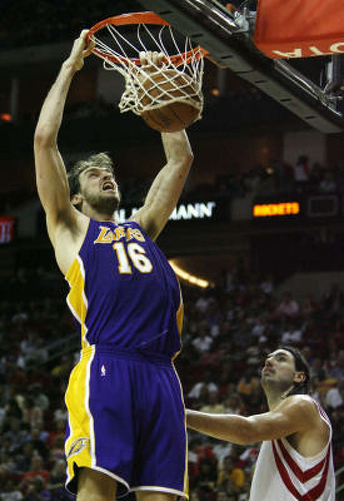 Lakers center Pau Gasol (16) throws down a dunk in front of Rockets forward Luis Scola.