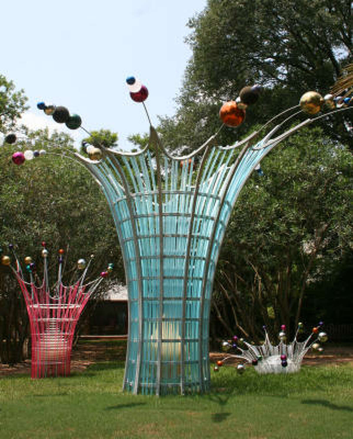 The Dennis Oppenheim creation includes three sculptures (from left) Splash (Tall Pink), Splash and Splash (Low White). The sculptures are made with colored stainless-steel globes, powder-coated steel, stainless-steel ties and acrylic.
