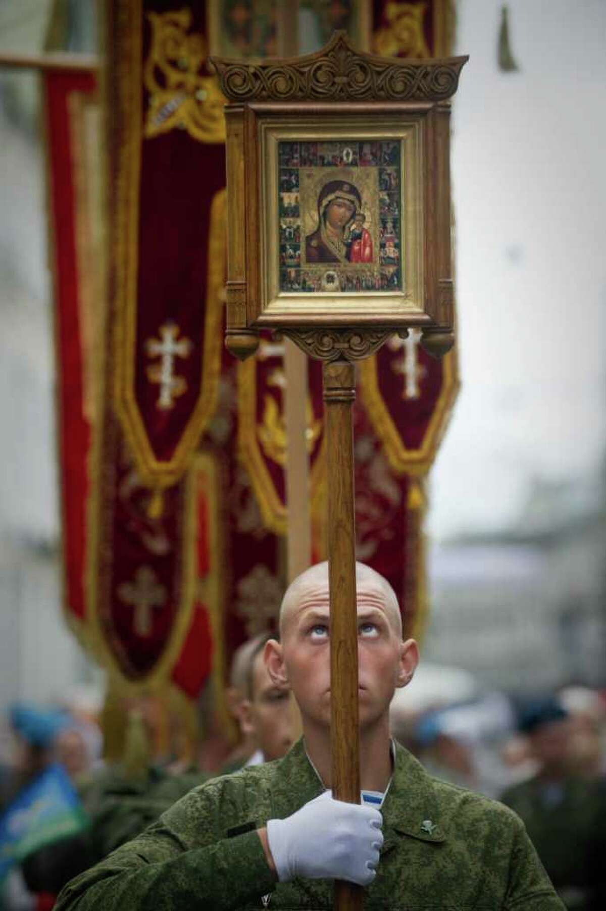 A Russian paratrooper carries a Russian Orthodox icon during a ceremony on Moscow's Red Square on August 2, 2011. Russians celebrated Paratroopers' Day on Tuesday, a tradition to honor the elite troops, carried over from Soviet times. AFP PHOTO / DMITRY KOSTYUKOV