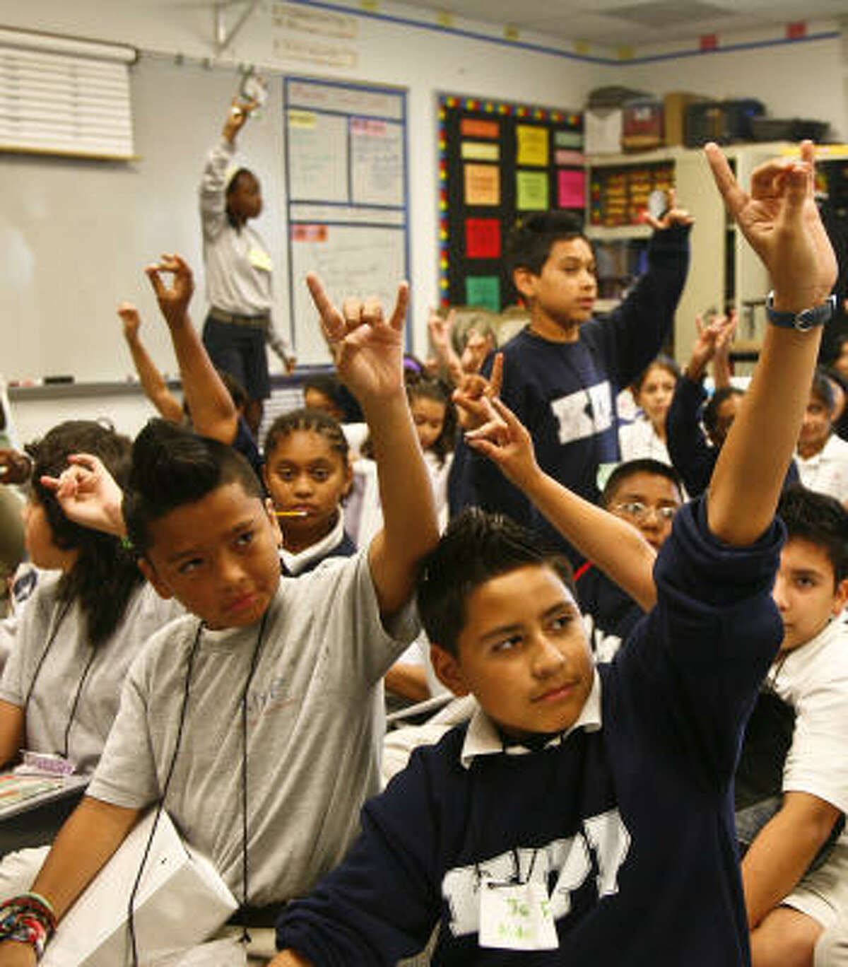 Sixth-graders raise their hands in response during a summer session class Monday at KIPP Academy. KIPP touted results of a study that dismisses questions about KIPP's methods.