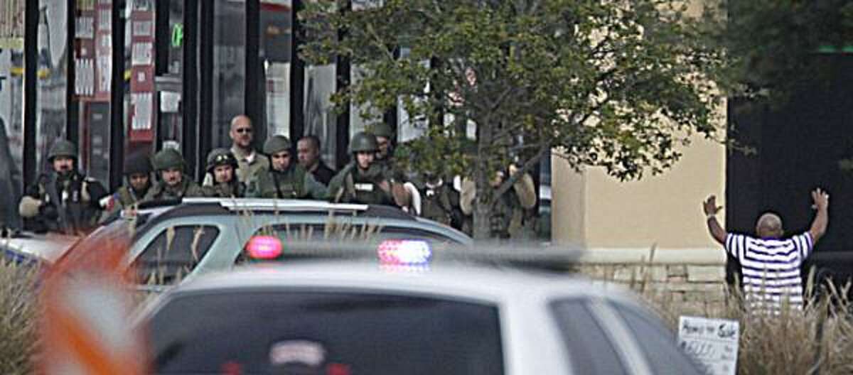 An unidentified hostage leaves the Pearland bank where two robbers had been holding hostages. Police had been negotiating with robbers. The bank's manager was injured early in the ordeal when he was struck by one of the robbers, police said. The manager escaped and was treated for his injuries.
