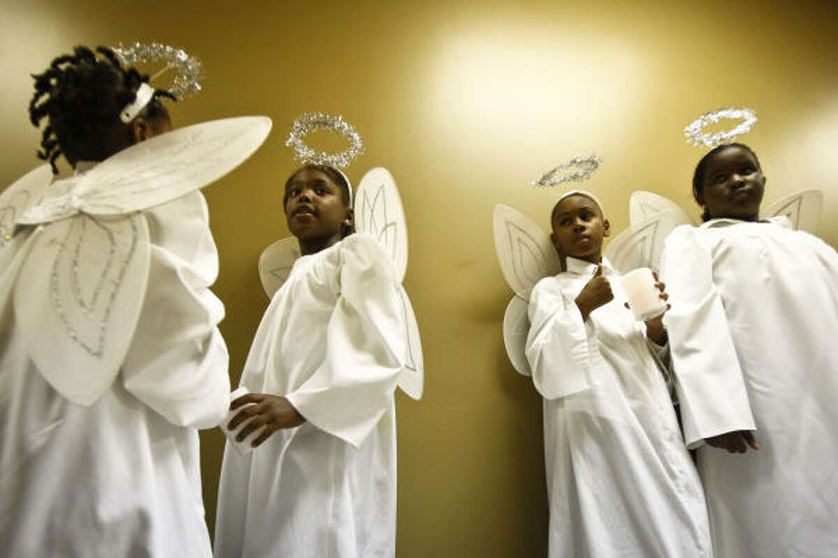 (From left) Angels Ayana Obas, 5; Briana Flowers, 8, Nathan Warren, 8, and Jalah Johnson, 10, wait to sing at the Church Without Walls' Christmas Eve Service at its Queenston Campus in Houston.