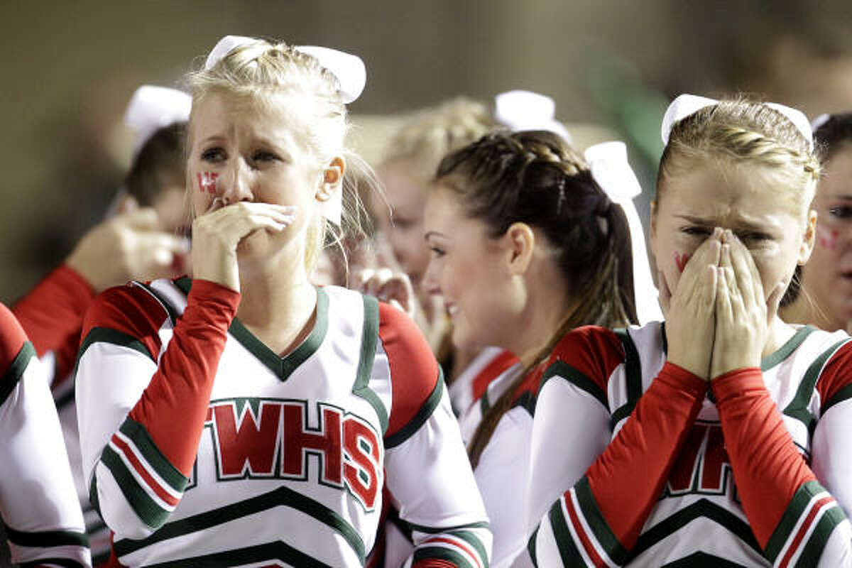 Cheerleaders for The Woodlands cry after their team's loss to Klein Oak.