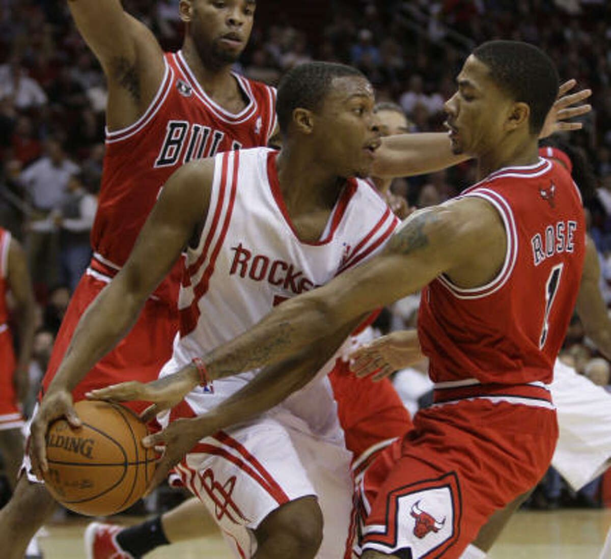 Rockets guard Kyle Lowry, left, looks to get past Bulls guard Derrick Rose, right, during the first quarter.