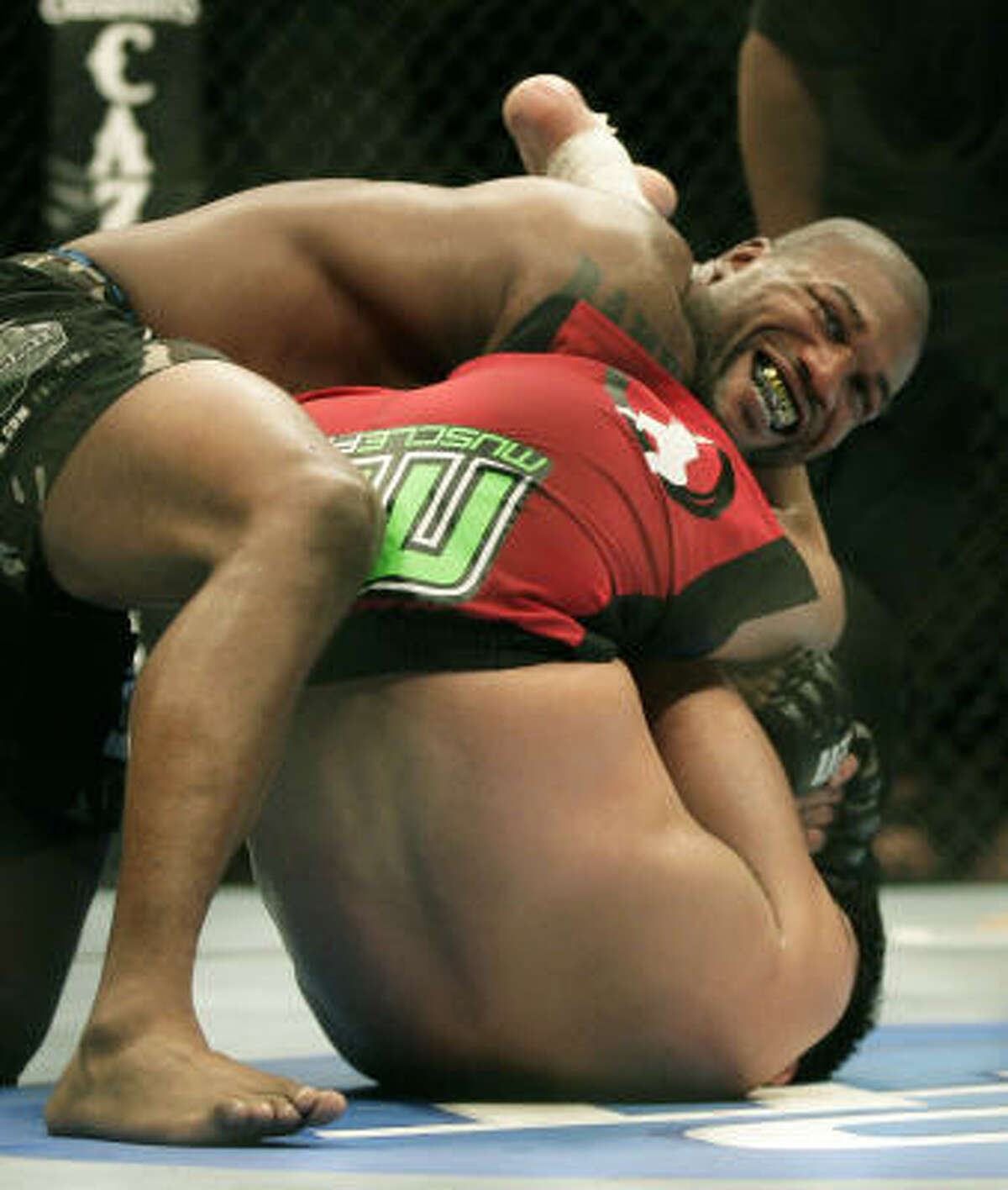 Quinton Jackson, top, wrestles Lyoto Machida, of Brazil in the main event of UFC 123.