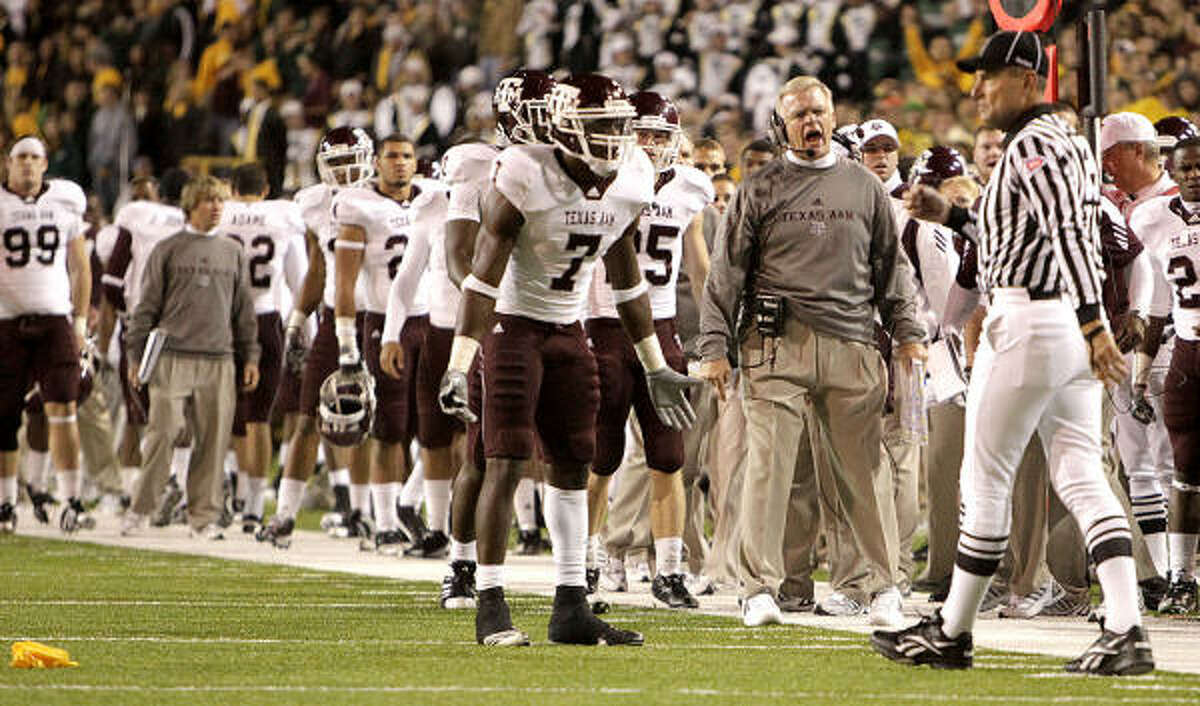 Texas A&M coach Mike Sherman, center, and wide receiver Uzoma Nwachukwu (7) protest a flag thrown by official Al Green, right, that nullified a touchdown reception by Nwachukwu in the second quarter.