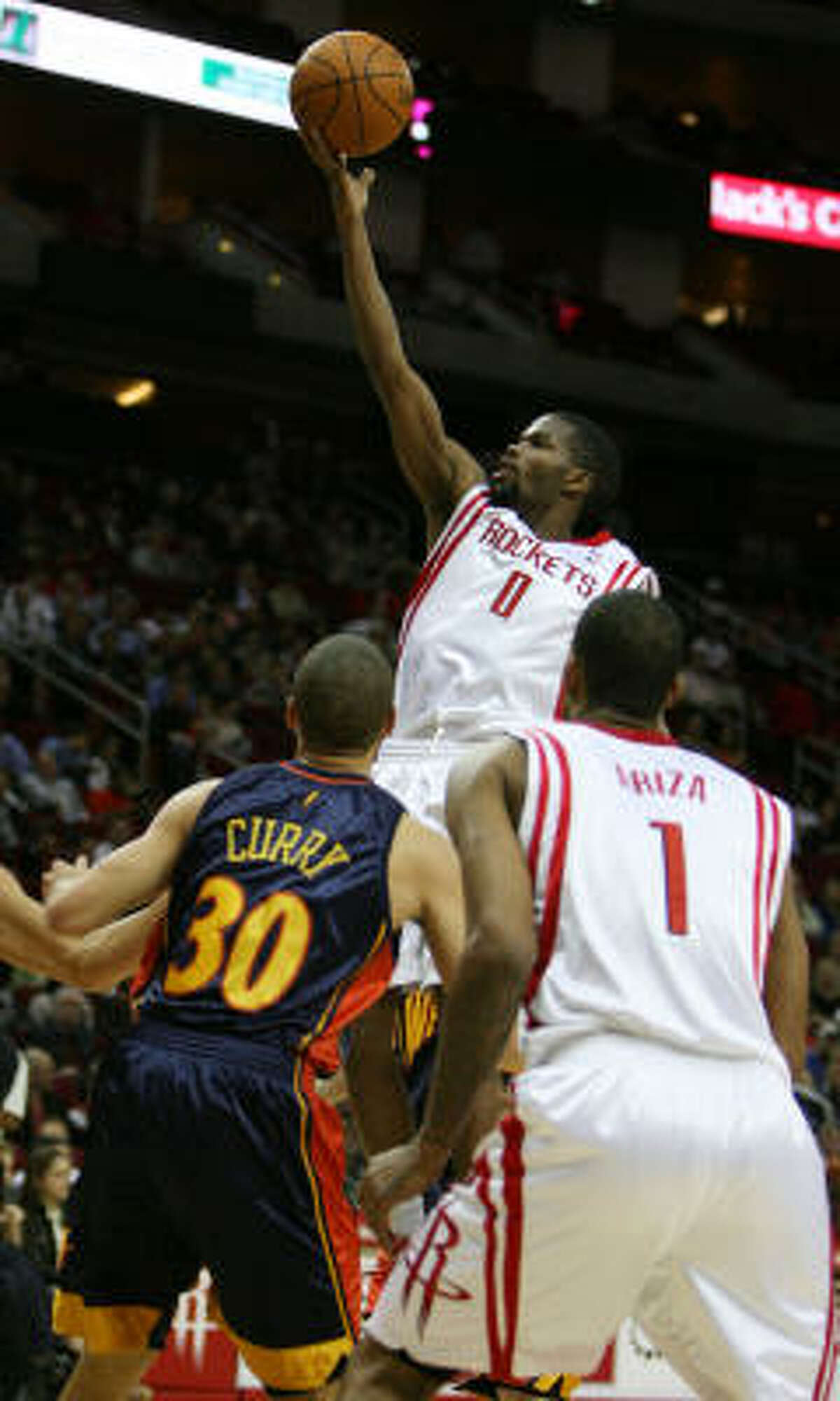 Rockets guard Aaron Brooks goes up for a finger roll over Stephen Curry.