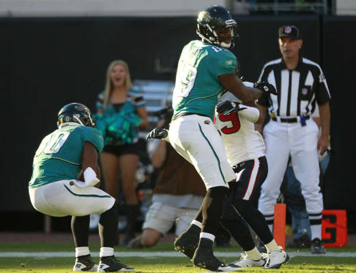 Jaguars wide receiver Mike Thomas, left, comes down with a 50-yard touchdown reception on the game's final play after a Texans defensive back batted a Hail Mary pass into his waiting arms.