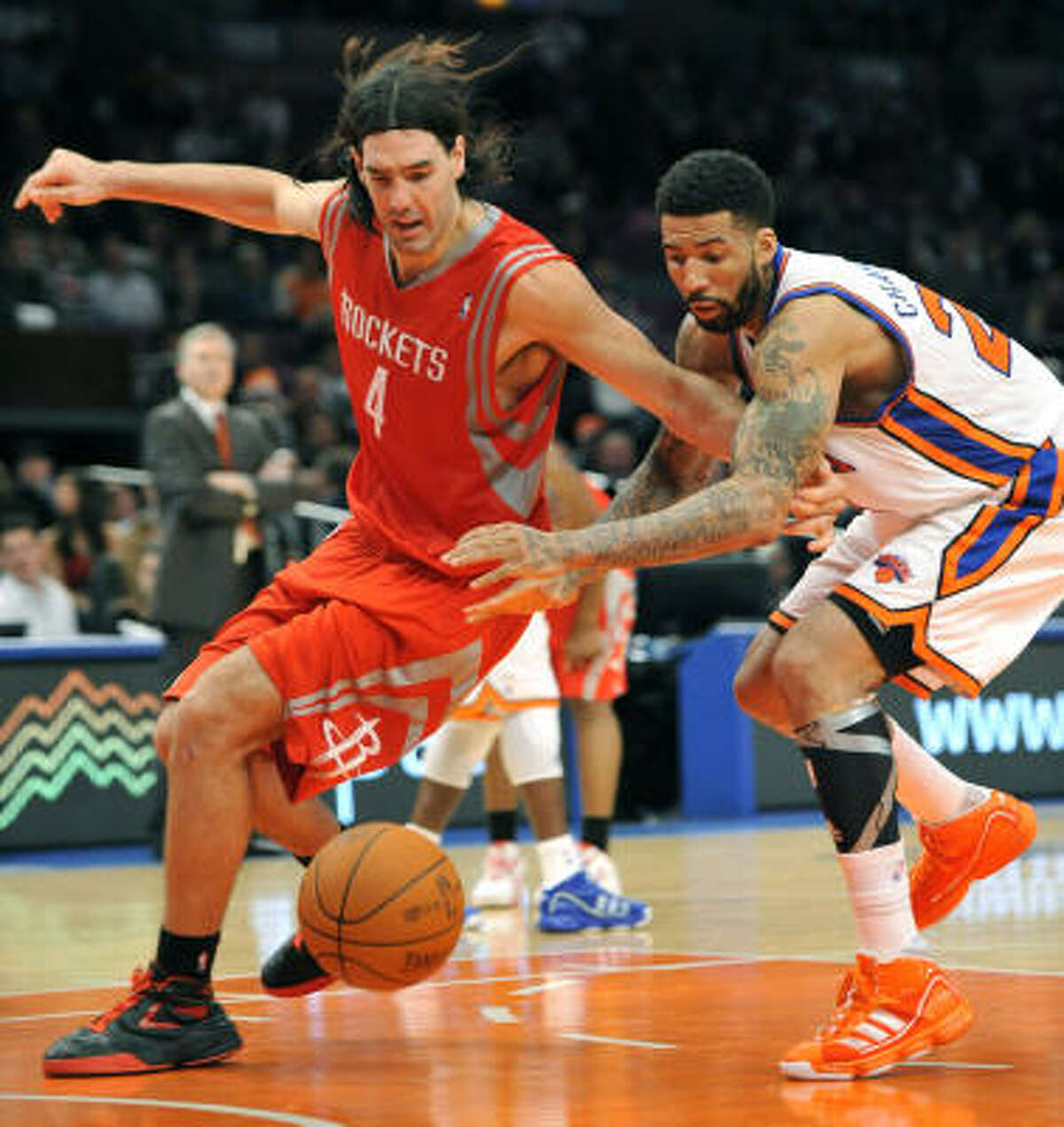 Rockets forward Luis Scola (4) and Knicks forward Wilson Chandler (21) scramble for a loose ball.