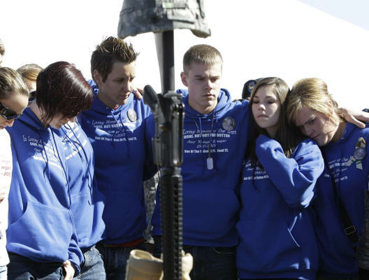 Friends and family of Staff Sgt. Amy Krueger, gather around her photo and a soldier's memorial following a Remembrance Ceremony commemorating the one-year anniversary of the worst mass shooting on a U.S. military base, where 13 people were killed and dozens wounded,Friday, Nov. 5, 2010 in Fort Hood, Texas. Krueger was killed int he shooing.