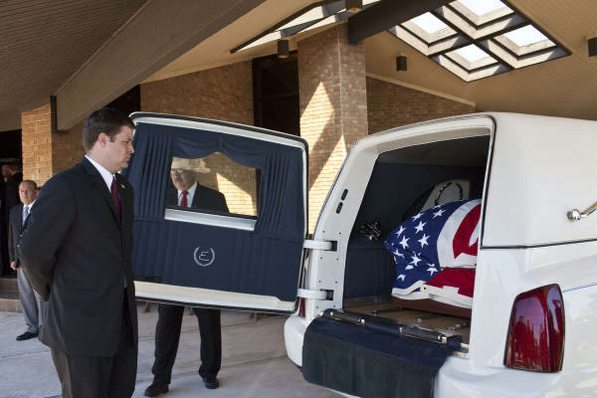 Funeral service workers close the door of a hearse containing the casket of David H. McNerney following services at Sacred Heart Catholic Church in Crosby.