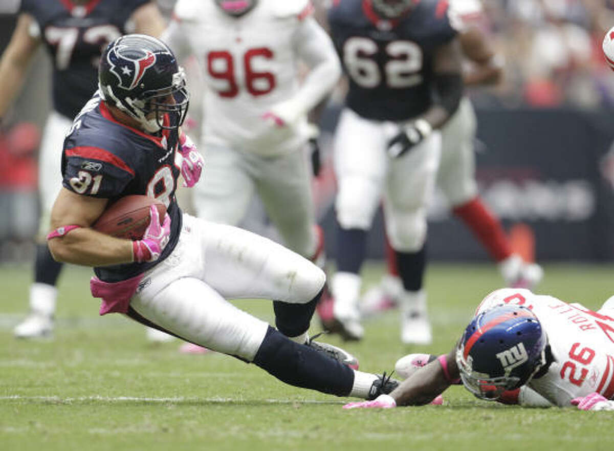 Texans tight end Owen Daniels is tripped up by Giants safety Antrel Rolle on a play in the second quarter of Sunday's game at Reliant Stadium. The Texans lost 34-10.
