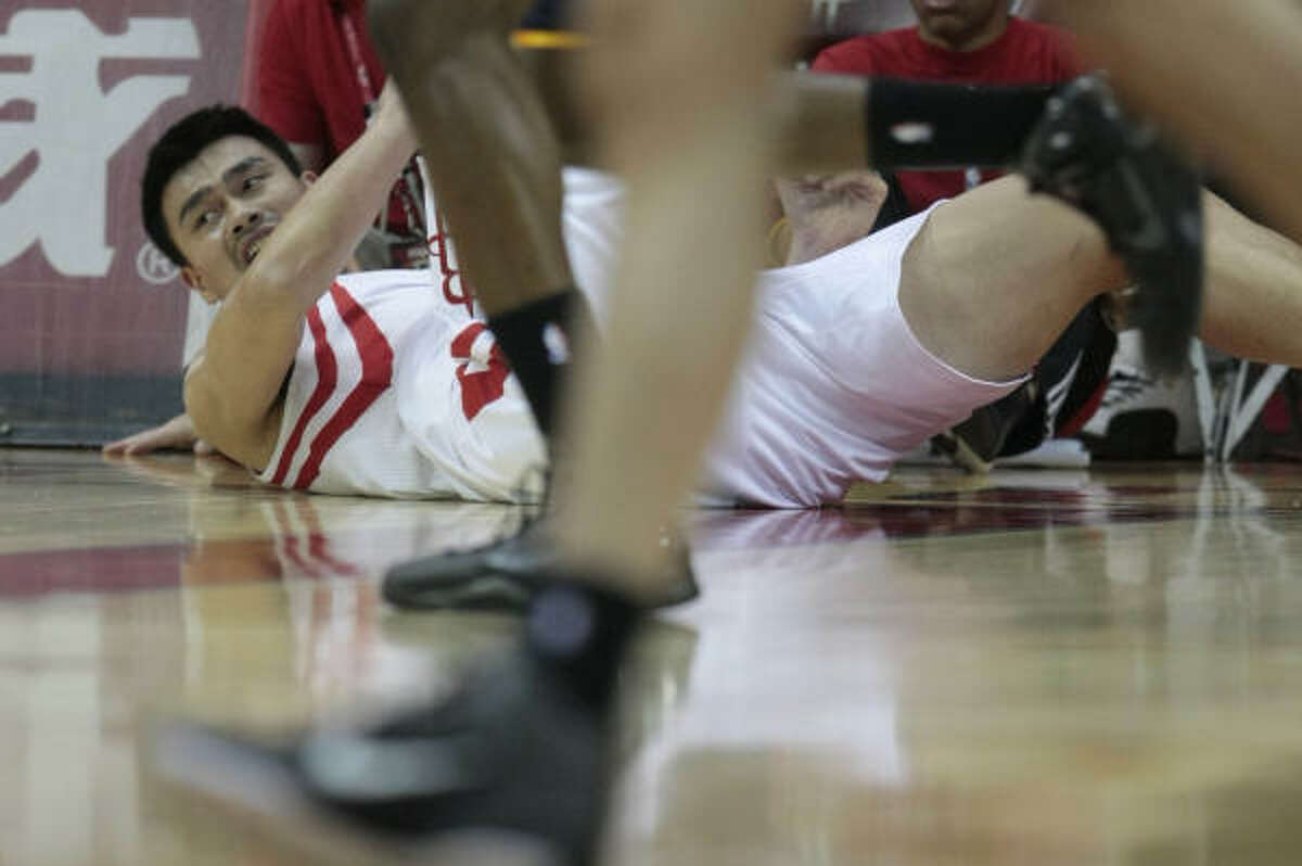 Rockets center Yao Ming looks down the court after falling while fighting for a loose ball.
