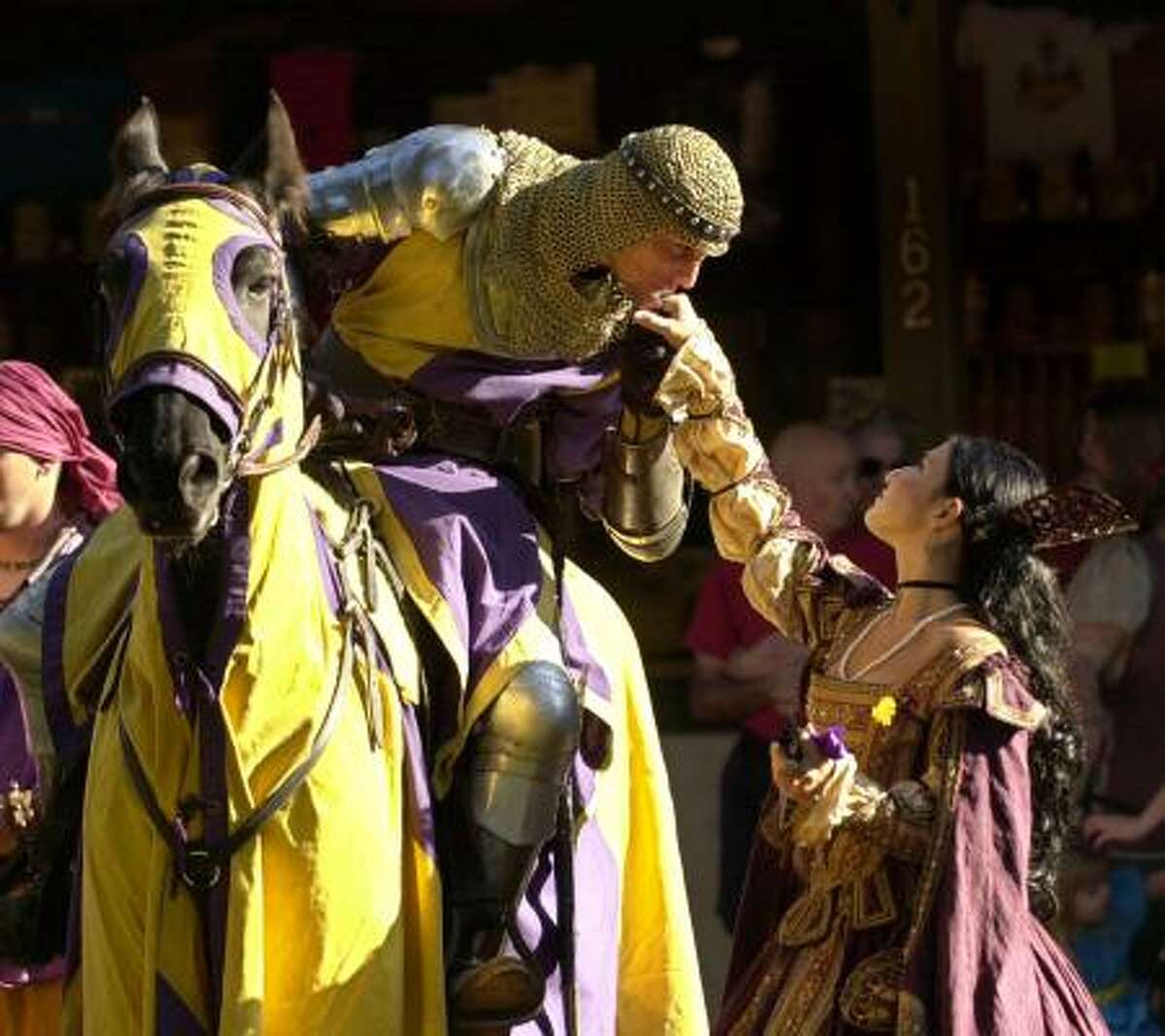 Knight Don Rodrigo Duke of Santiago, played by Chris Mitri Dynneson, kisses the hand of Dona de Salamanco, played by Sylvia Salamanca during the opening ceremony at the Texas Renaissance Festival in 2003.