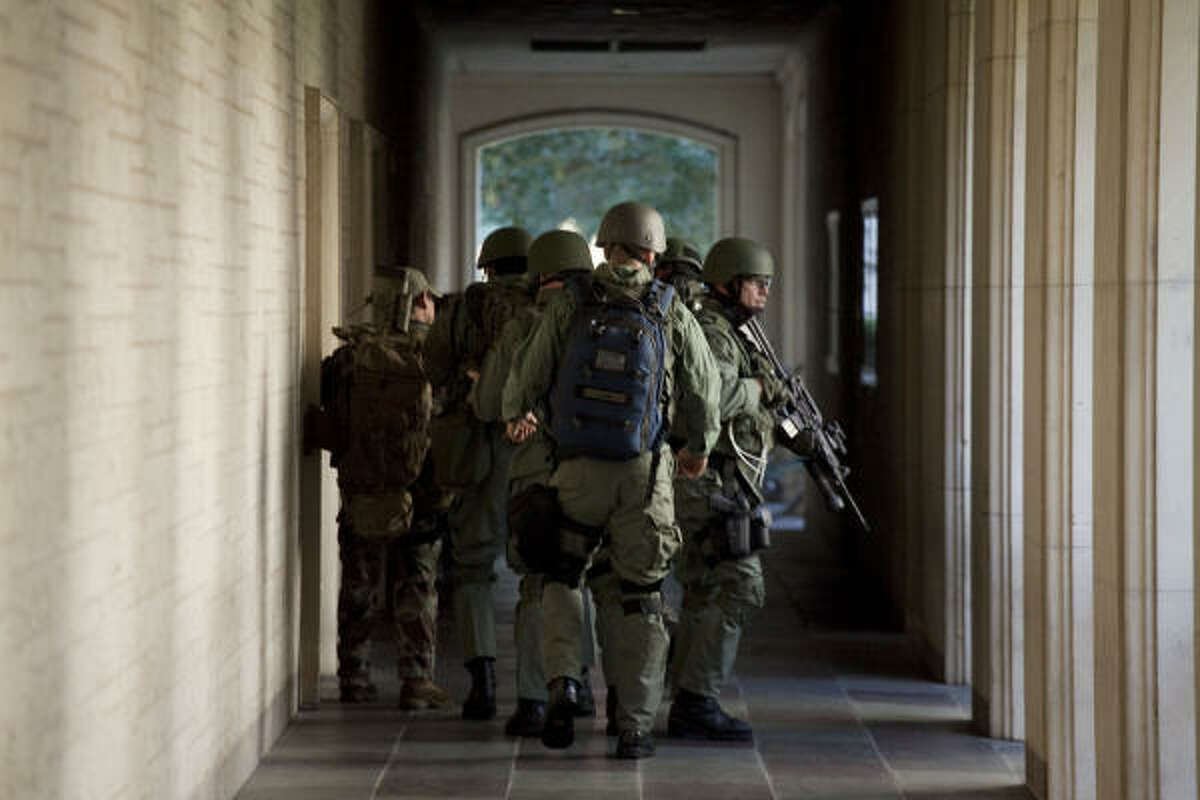 Police prepare to enter Calhoun Hall near the Perry-Castañeda Library where a 19-year-old sophomore math major killed himself Tuesday with an AK-47.
