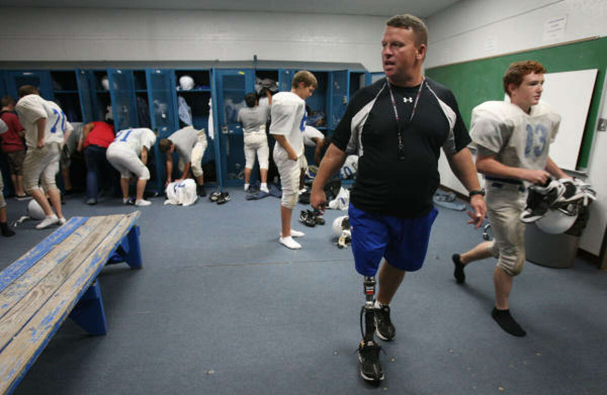 Nathan Potts instructs his team to get dressed and out to the field as soon as possible at the start of Tuesday's practice at Shepherd Middle School in Shepherd. Potts, a former assistant coach at Fort Worth Dunbar High School, coaches sub-varsity at Shepherd with former Dunbar coach Bob Jones. He left coaching to join the military after the terrorist attacks of 9/11 and had to have his leg amputated before returning to coaching.