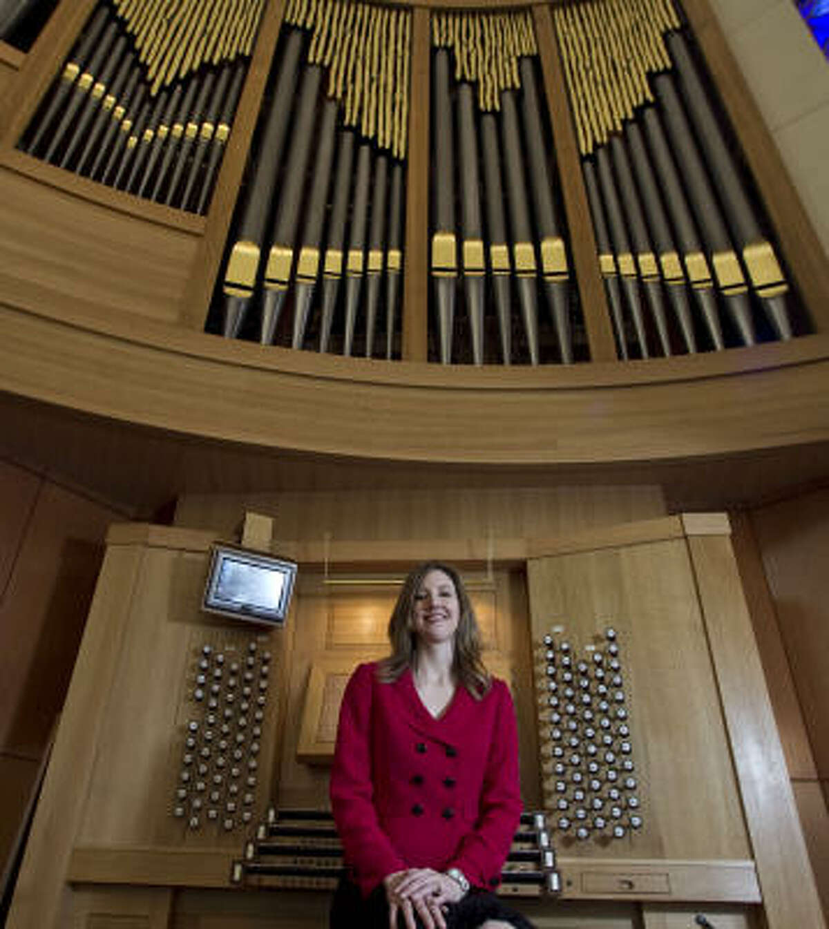 Organist Crista Miller poses for a portrait with the new pipe organ.