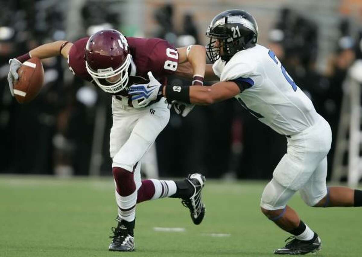 Sept. 11: Cinco Ranch 38, Clear Springs 35 Cinco Ranch's Bobby Waid, left, fights for extra yardage against the defense of Clear Springs' Jesse Washington in the second quarter of Saturday's game at Rhodes Stadium.