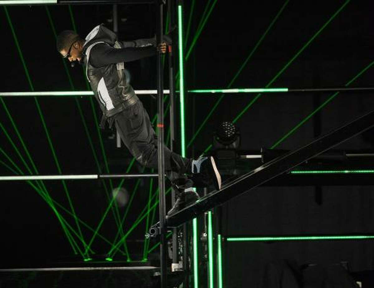 Usher "just hangin" from the rafters of the stage during his performance.