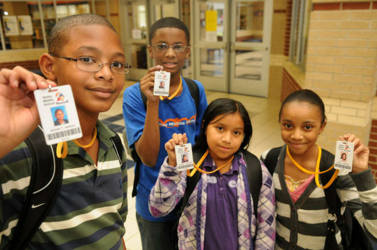 Sixth-graders, from left, Jacorey Jackson, Deante' Maxey, Casandra Hernandez and Kamryn Jefferson, all 11, wear special tracking badges at Bailey Middle School in Spring.