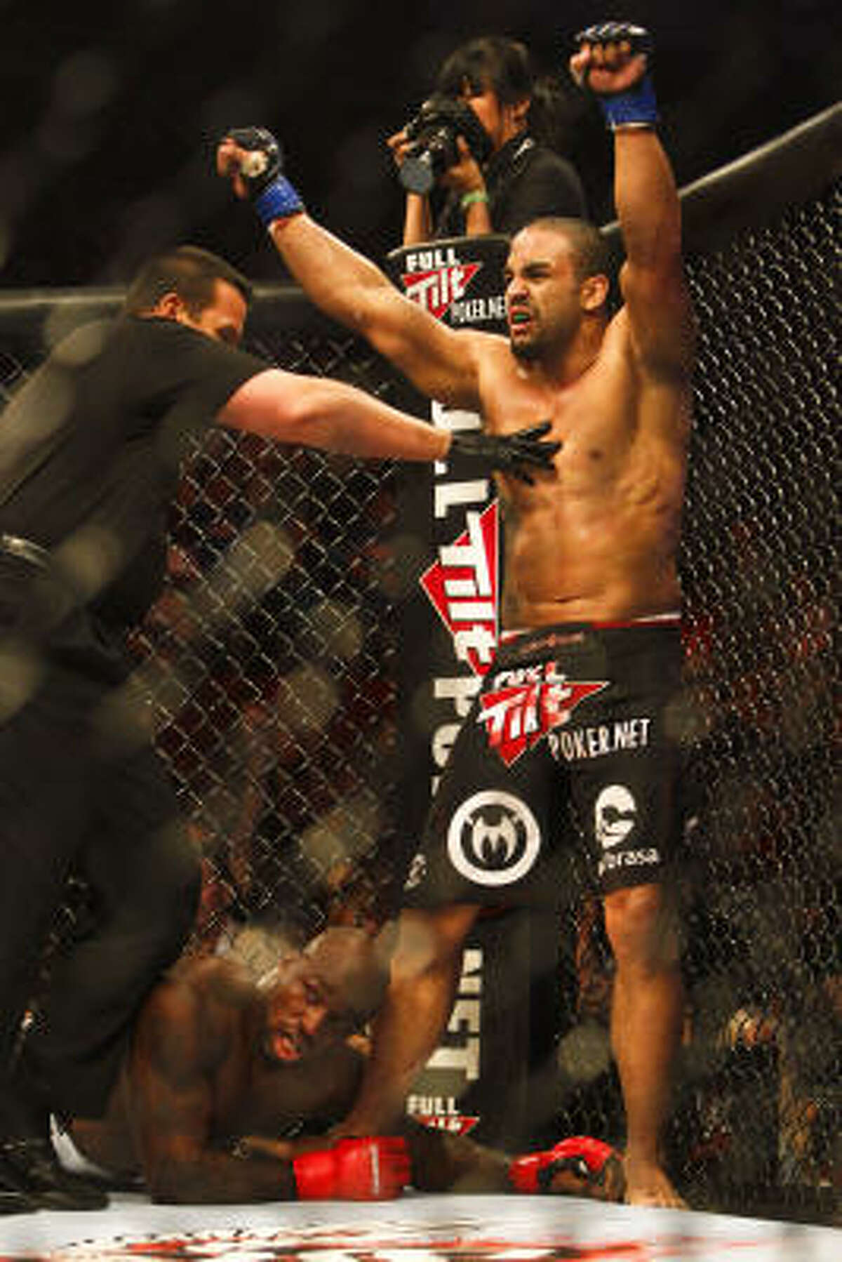 Rafael "Feijao" Cavalcante celebrates as the ref steps in to call the fight as "King" Mo Lawal falls to the ground.