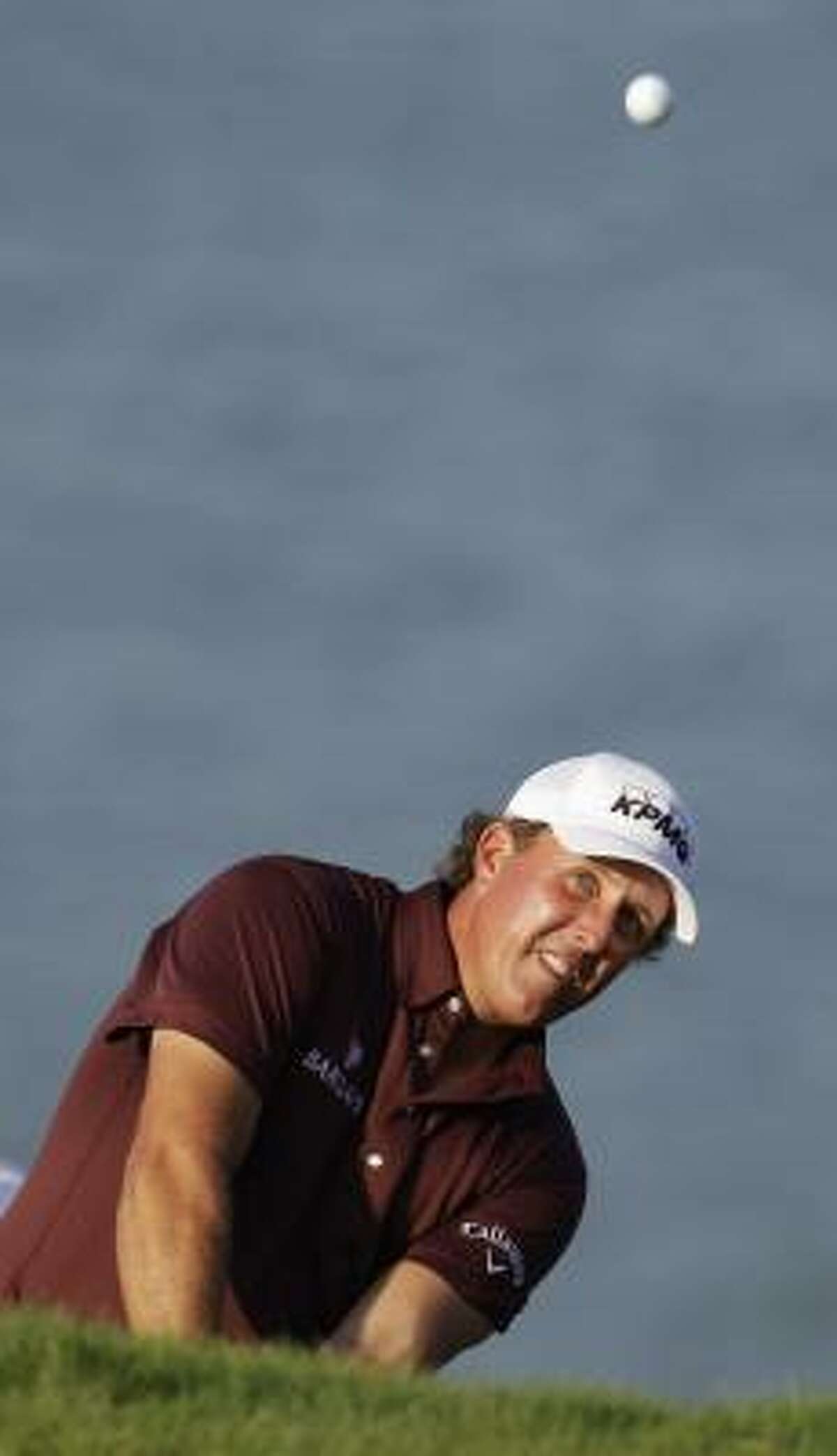 Phil Mickelson hits out of a bunker on the fourth hole.