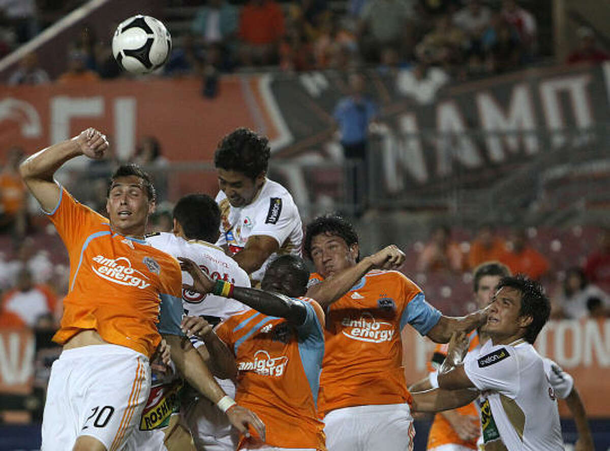 Dynamo midfielder Geoff Cameron and forwards Dominic Oduro and Brian Ching go for a corner kick.