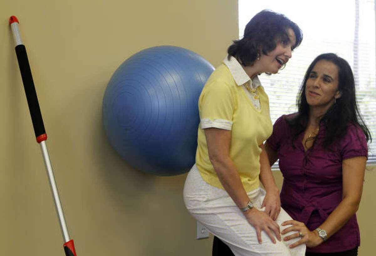 Helms exercises with physical therapist Claudia Puett in the Woodlands. Helms hopes to walk again.