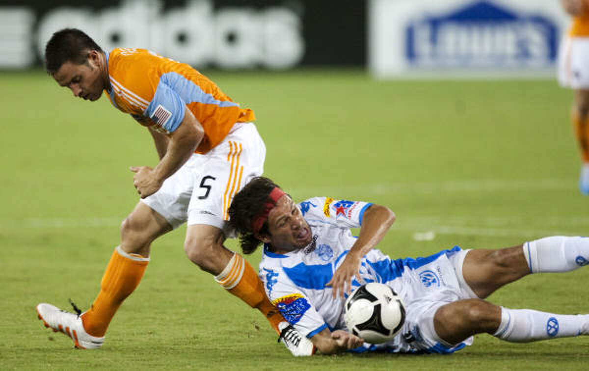Dynamo midfielder Danny Cruz, left, and Puebla forward Gabriel Pereyra get tangled up while fighting for a ball in the second half.