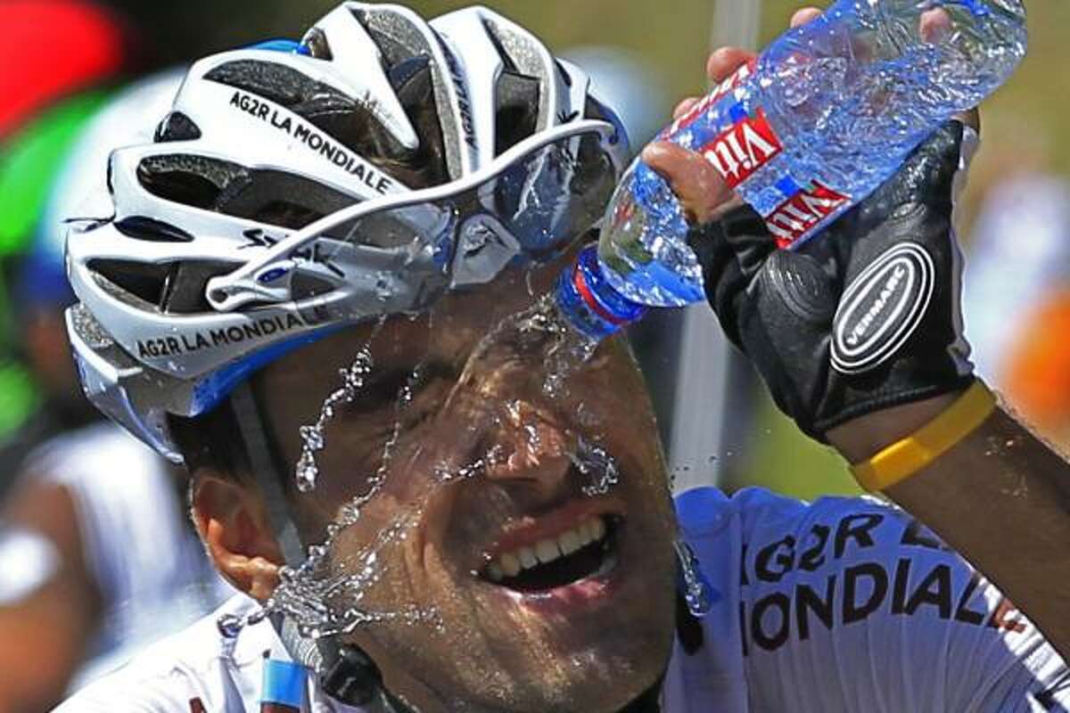 Stage winner Christophe Riblon of France cools off with a bottle of water as he climbs towards Ax-3 Domaines during the 14th stage.