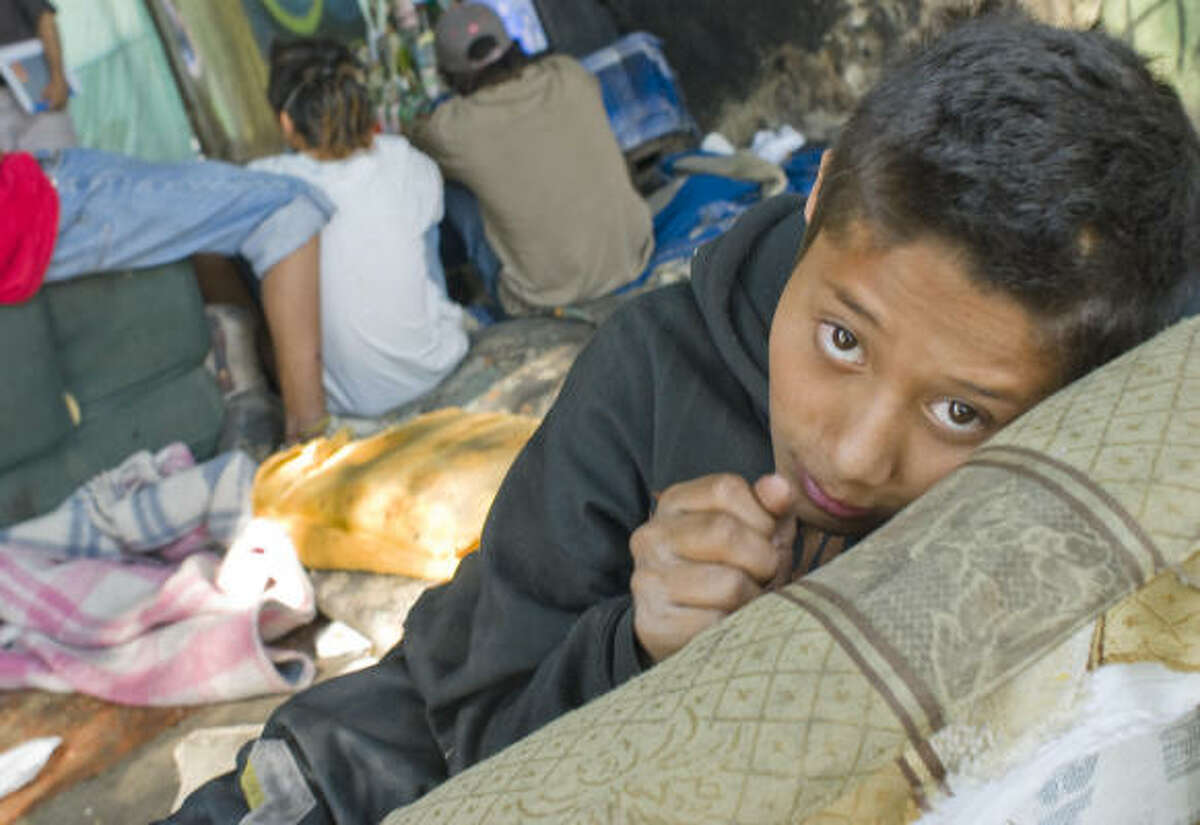 In the southern part of the city under an expressway overpass, a squalid camp is home to some 25 children, adolescents and young adults who have decided to make the streets their home. Jonathan Raigosa, 15, is seen in the camp.