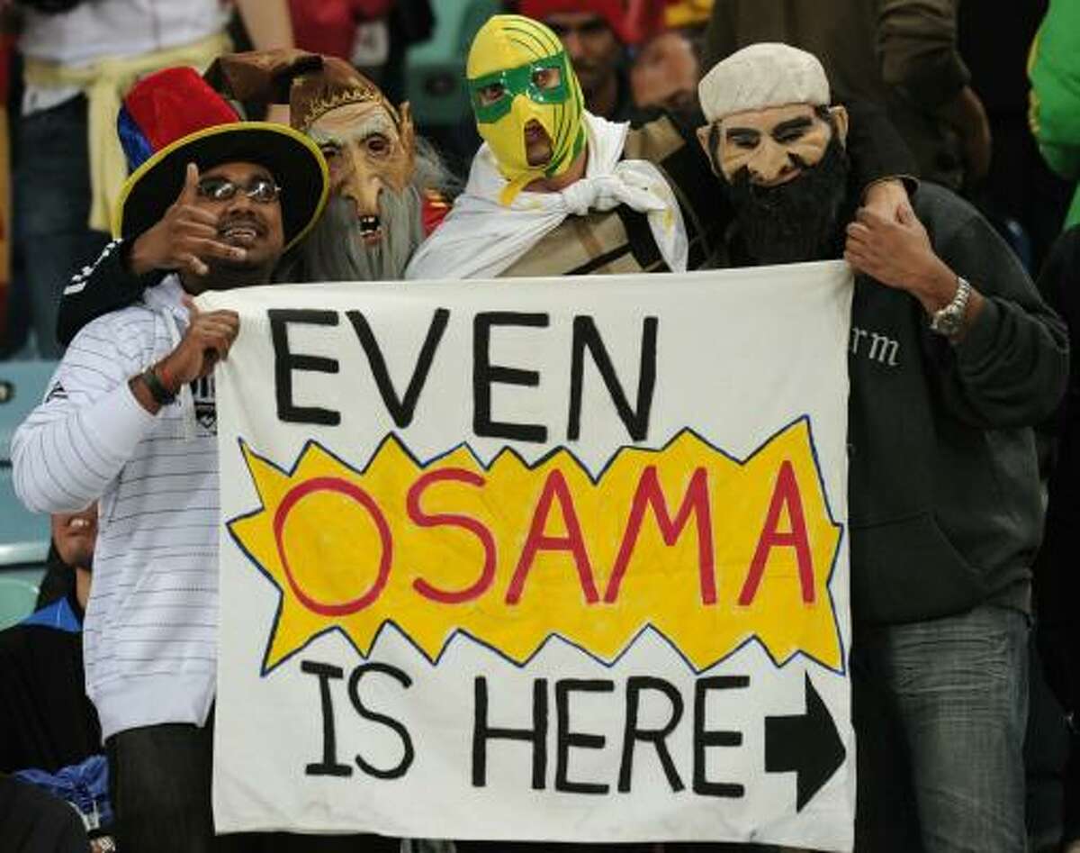 Fans wearing masks hold up a banner in reference to terrorist Osama bin Laden at Moses Mabhida stadium in Durban.