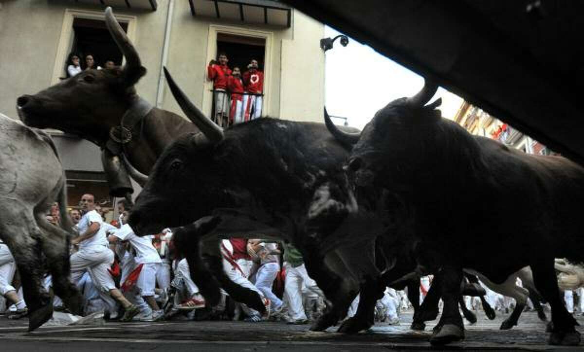Penajara Ranch fighting bulls and steers take a corner during the first bull run of the San Fermin Fiesta on July 7, 2010 in Pamplona, Spain. Fighting bulls run through the historic heart of Pamplona for eight days in this fiesta made famous by the 1926 Ernest Hemingway novel, 'The Sun Also Rises.'