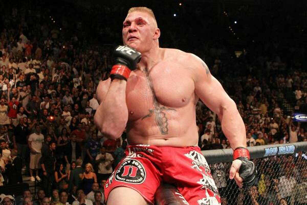 Brock Lesnar sits on the cage as he celebrates his win over Shane Carwin in the title fight.