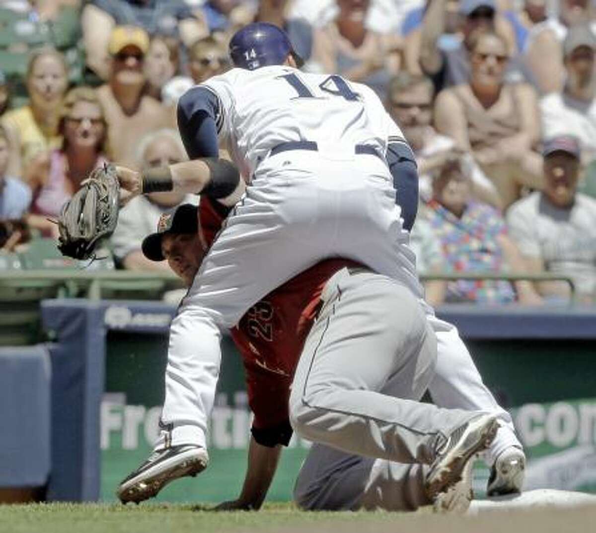 Brewers' Casey McGehee, top, straddles Astros third baseman Chris Johnson after being tagged out on a ball hit by Carlos Gomez during the second inning.