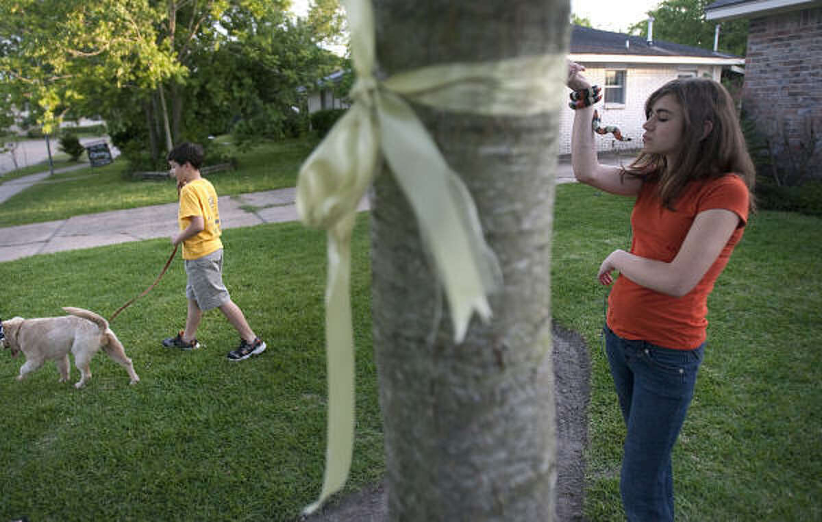 Michael Hanus, 9, walks 'Joy', a newly adopted dog, as Megan Hanus, 13, brings pet snake 'Rocket' along for an afternoon walk in Houston. The Hanus Family adopted a new puppy in the absence of their father.