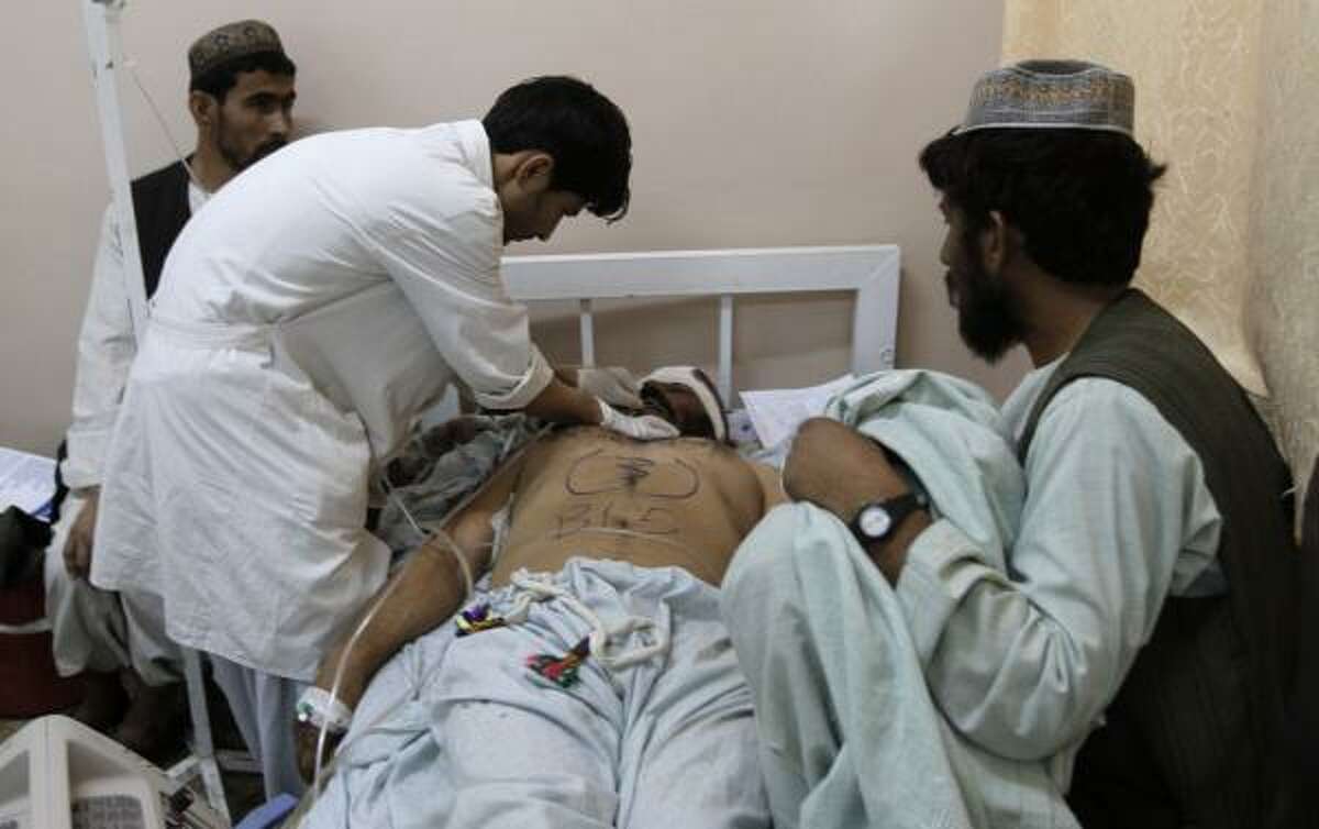 A medical staffer helps a wounded man at a hospital following a blast at a wedding party in Kandahar city, Afghanistan, Thursday, June 10, 2010. NATO blamed the Taliban for the suicide attack that killed at least 40 Afghan wedding guests in an area where U.S.-led troops are massing to drive insurgents from their fiefdom. Officials said a suicide bomber strapped with explosives had walked into on June 9 wedding party -- which relatives said was attended by members of an anti-Taliban militia -- and unleashed a deadly hail of ballbearings. At least 40 killed in Taliban suicide bombing at wedding in Afghanistan