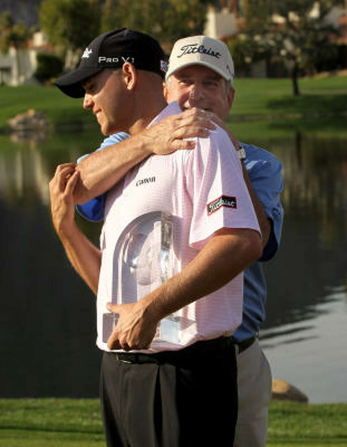 Bill Haas, left, is congratulated by father and former tournament champion Jay Haas on the 18th green after his victory at the Bob Hope Classic in January.