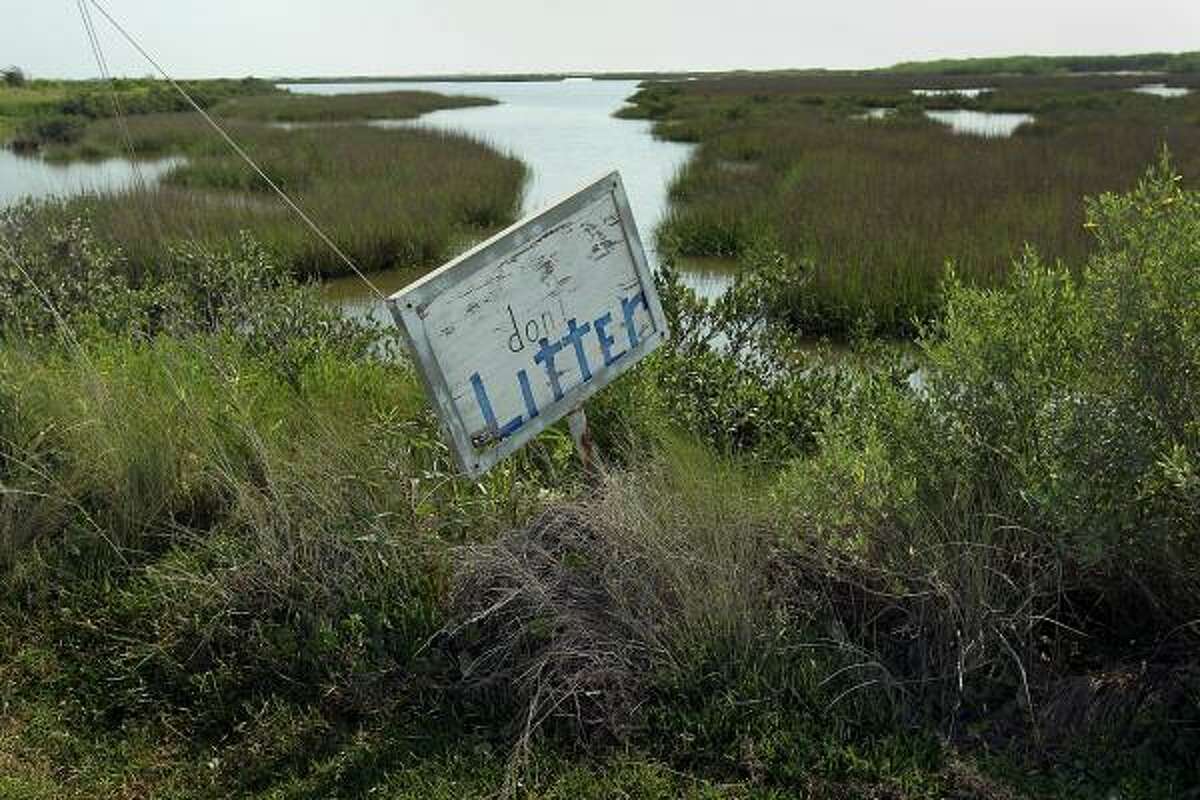 A 'don't Litter' sign stands posted next to an estuary near an oil-soaked beach on May 25, 2010 at Port Fourchon, La. Cleanup crews had worked for days trying to remove oil from nearby beach to try and keep the oil from seeping into the marshlands.