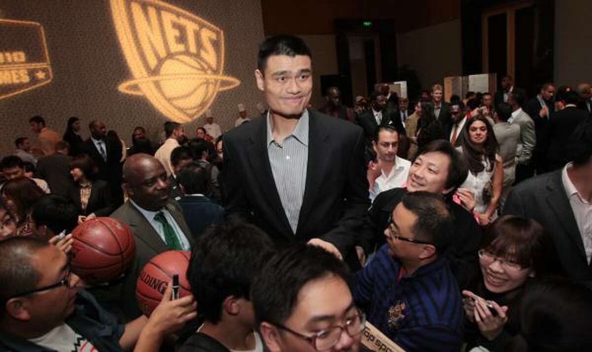 Rockets center Yao Ming expresses some tension as fans push to get his attention at a hotel reception Tuesday marking his return for the China Games in Beijing.