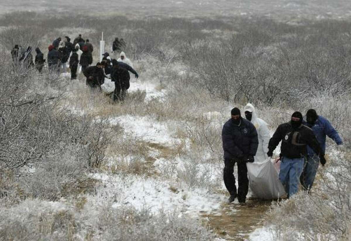 The scene of police and forensic workers carrying corpses of gang victims, like this 2009 incident near Ciudad Juarez, is all too common, citizens groups complain.