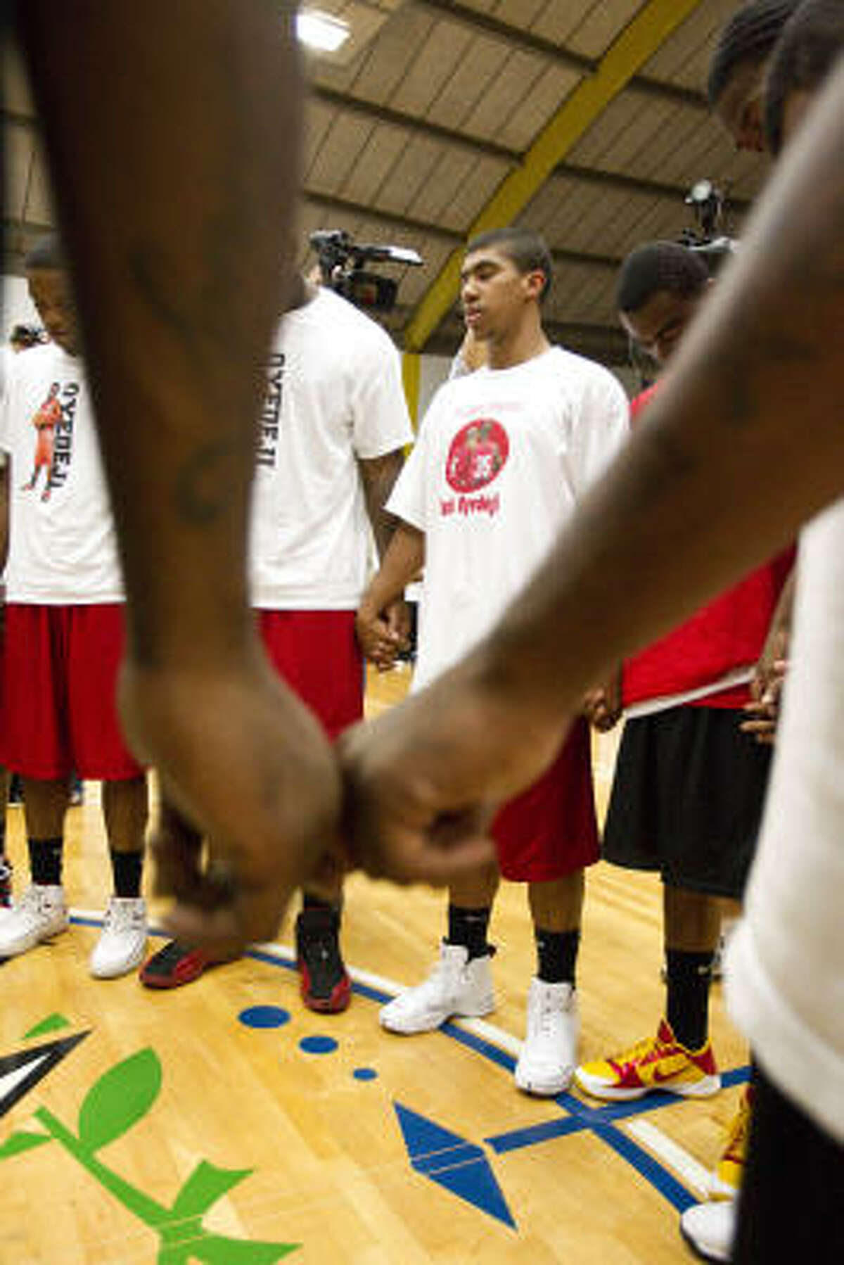Jonathan Evans leads Bellaire and Yates high school in a prayer before a charity basketball game in memory of Tobi Oyedeji.