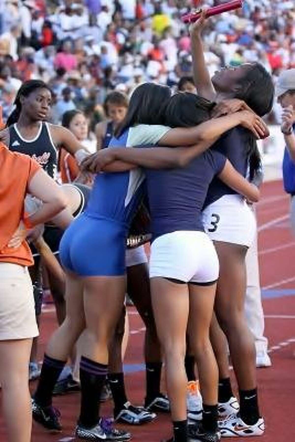 The Lamar girls celebrate their 1,600-meter relay victory with Taylor Houston of Elkins, which finished third.