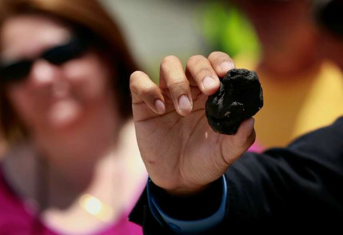 Louisiana Gov. Bobby Jindal shows off a ball of tar-like substance said to be oil from the oil spill off the Louisiana coast.