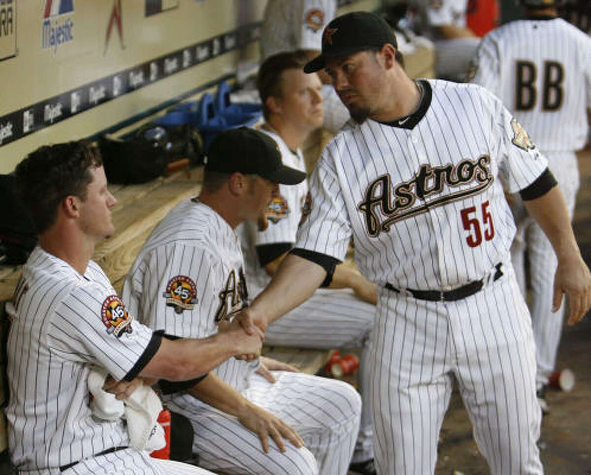 Astros catcher Humberto Quintero, right, shakes the hand of starter Roy Oswalt after Oswalt was pulled from the game in the sixth inning.