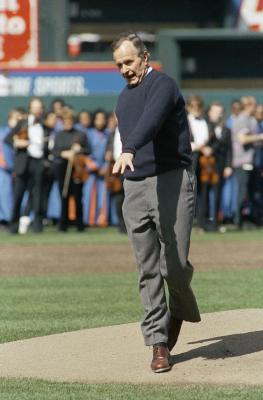 President George H.W.Bush reacts after throwing a one-hopper, the